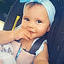 baby, child, car_seat, blue_bow, headband, blanket, smile, face, hand, sitting, seatbelt, clothing, cute, portrait, indoors, infant, person, happy, car, safety