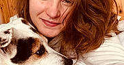 Roxy participe au concours pour gagner de l'argent avec cette photo : woman, dog, cuddle, smile, red_hair, white_sweater, indoor, wooden_wall, pet, closeup, portrait, face, animal, friendship, cozy, casual, love, hand, ring, resting