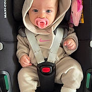 Marla is registered to the contest to win money with this photo: baby, infant, child, car_seat, pacifier, hoodie, sweatsuit, sneakers, nike, plush_toy, pink, white, seatbelt, maxi_cosi, cute, indoors, portrait, baby_clothing, small_child, comfort