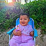 baby, child, pink_dress, blue_chair, beach, sand, greenery, plants, palm_trees, sunlight, smiling, happy, outdoor, tropical, nature, portrait, seated, summer, cute, toddler