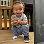Adonis joined the competition — help win amazing prizes! toddler, child, smiling, shoe, squatting, wooden_deck, play_structure, gray_shirt, blue_pants, sock, outdoor, happy, curly_hair, casual_clothing, playtime, daylight, wood, person, cute, fun