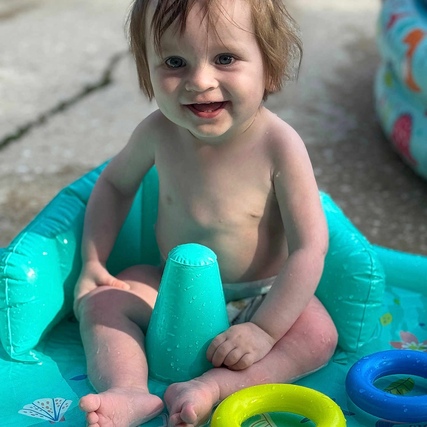 Laurence joined the competition — help win amazing prizes! barefoot, blue, child, fun, happy, inflatable_pool, outdoor, play, sitting, smiling, splash, summer, sunlight, toddler, toy_ring, water, water_toy, wet, yellow, young_child