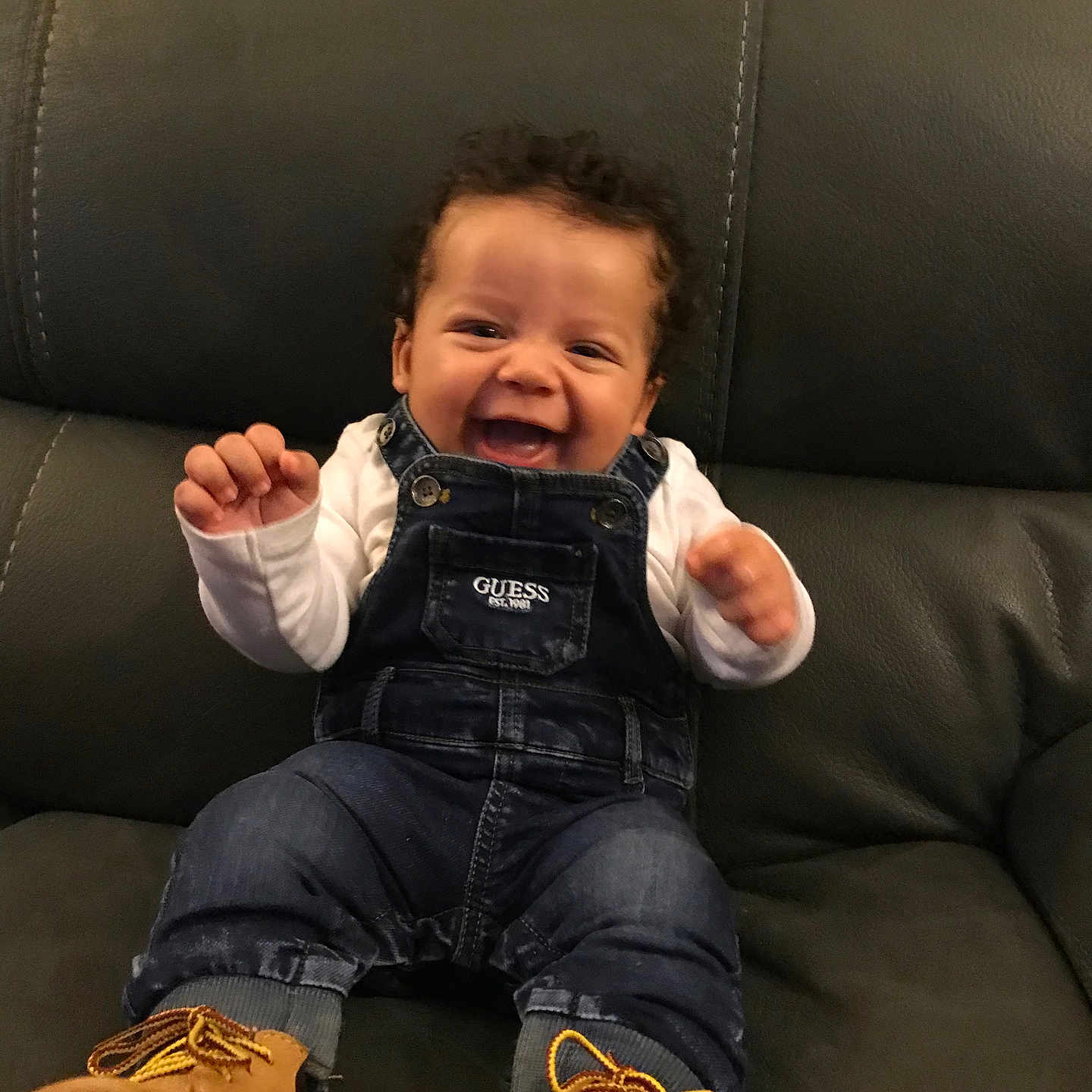 Zaire joined the competition — help win amazing prizes! baby, babylaughing, bodypart, clothing, coat, couch, cushion, face, finger, footwear, furniture, hand, happy, head, homedecor, jacket, jeans, laughing, pants, person