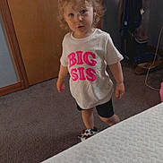 Blakleigh joined the competition — help win amazing prizes! bed, carpet, child, curly_hair, door, expression, footwear, furniture, home, indoor, looking_up, person, playful, plush_slipper, room, standing, text, toddler, tshirt, vacuum_cleaner