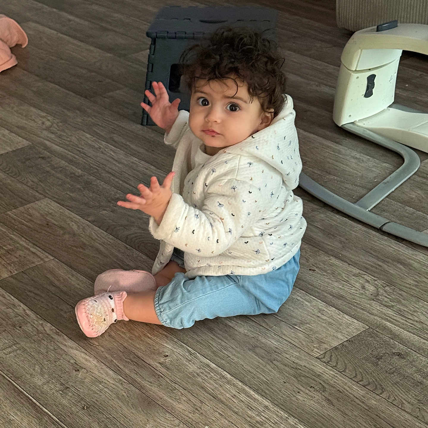 Léa a rejoint le concours — aidez-le/la à gagner de superbes lots ! baby, blue_pants, child, cozy_clothing, curiosity, curly_hair, cute, expression, flooring, hands_raised, home, indoor, looking_up, person, pink_socks, sitting, toddler, white_hoodie, wooden_floor, young_child