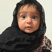 Manha joined the competition — help win amazing prizes! baby, child, face, headscarf, black_clothing, lace, patterned_clothing, wide_eyes, innocent_expression, portrait, person, young_child, cute, curious, indoors, close_up, skin, hand, head, clothing