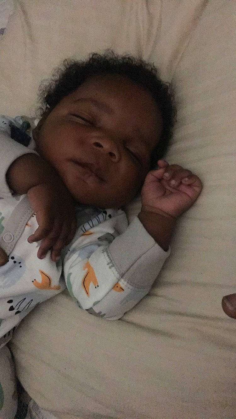 Arion is registered to the contest to win money with this photo: baby, baby_toddler_clothing, bed, cheek, chin, comfort, eye, eyebrow, face, gesture, hair, happy, head, human_body, linens, mouth, nose, person, sleeve, thumb