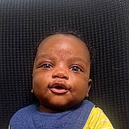 Makari joined the competition — help win amazing prizes! baby, infant, face, closeup, portrait, smile, clothing, bib, yellow, blue, skin, eyes, mouth, expression, background, textured, cute, child, person, indoor