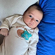 Eyden a rejoint le concours — aidez-le/la à gagner de superbes lots ! baby, blue_pillow, child, comfort, couch, cozy, cute, expression, eyes, face, hand, indoor, infant, lying_down, onesie, pacifier, pillow, soft_texture, white_clothing, young