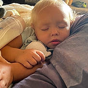 Mya a rejoint le concours — aidez-le/la à gagner de superbes lots ! baby_bottle, blanket, child, closeup, clothing, comfort, cozy, face, hair, hand, indoor, light, nap, peaceful, person, relaxation, rest, sleeping, soft_toy, toddler