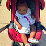 baby, casual, child, cute, daylight, footwear, infant, outdoor, peaceful, person, red, seatbelt, shoes, sidewalk, stroller, summer, sunlight, toddler, transportation, white_dress