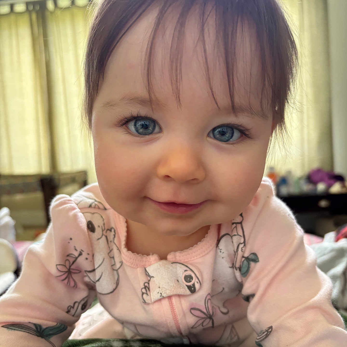 Amelie joined the competition — help win amazing prizes! baby, blue_eyes, child, close_up, cozy, curtains, cute, expression, face, hair, indoor, infant, koala_print, person, pink_onesie, portrait, smile, soft_light, window, young_child