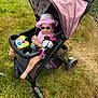 toddler, stroller, grass, toy, sunglasses, hat, bottle, outdoor, child, baby, footwear, purple, play, mickey_mouse, smile, sunhat, summer, relaxing, wheel, canopy