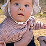 baby, child, face, bonnet, knitted_sweater, pink_clothing, hand, outdoor, natural_light, portrait, cute, infant, person, closeup, soft_texture, calm, curious, holding, skin, young