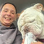 Penny is registered to the contest to win money with this photo: animal, bulldog, car, casual_clothing, closeup, cup, dog, friendship, fun, hand, happy, indoor, light, person, pet, selfie, smiling, tongue, whipped_cream, wrinkles