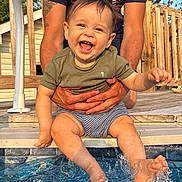 Sebastian joined the competition — help win amazing prizes! baby, child, smiling, happy, water, splashing, pool, outdoor, summer, person, feet, hands, clothing, toddler, playful, sunlight, deck, adult, holding, fun