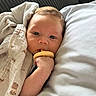 baby, blanket, pacifier, pillow, couch, face, hand, infant, child, comfort, rest, indoor, soft, sleepy, portrait, closeup, skin, head, eyes, cozy
