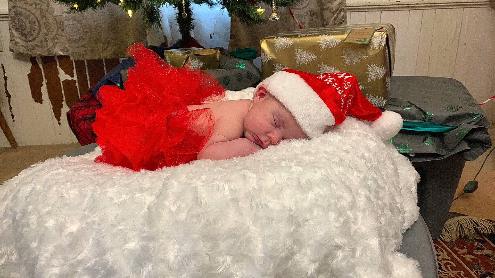 Brookelynn is registered to the contest to win money with this photo: baby, baby_toddler_clothing, bedding, carmine, christmas, christmas_eve, christmas_tree, comfort, event, fictional_character, fur, hat, headwear, holiday, lap, linens, person, red, room, santa_claus