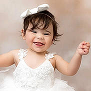 Leylah Nichole joined the competition — help win amazing prizes! baby, toddler, girl, smile, portrait, white_dress, bow_headband, lace, tulle, cute, adorable, dark_hair, teeth, ears, earrings, raised_hand, studio_background, soft_lighting, happy, person