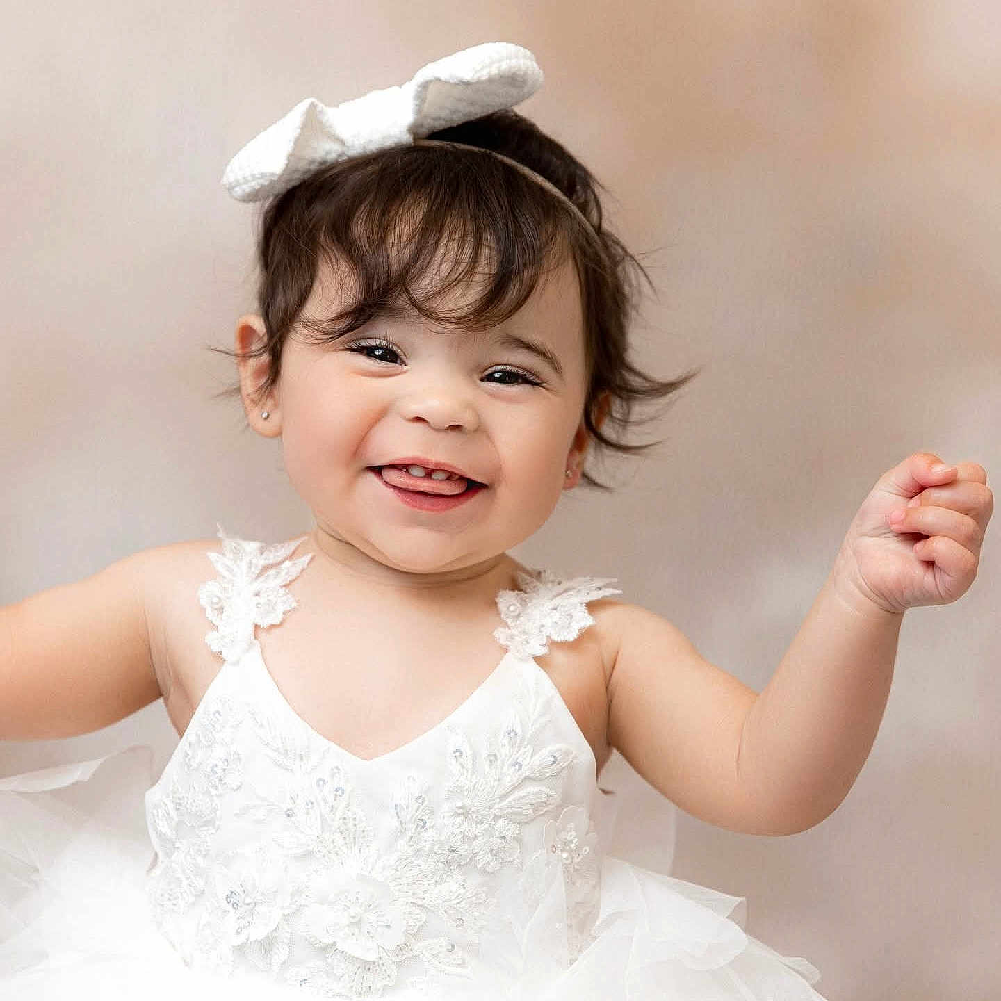 Leylah Nichole joined the competition — help win amazing prizes! adorable, baby, bow_headband, cute, dark_hair, earrings, ears, girl, happy, lace, person, portrait, raised_hand, smile, soft_lighting, studio_background, teeth, toddler, tulle, white_dress