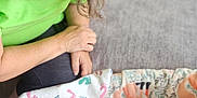 Natalie is registered to the contest to win money with this photo: baby, adult, glasses, blanket, couch, smile, indoor, child, person, green_shirt, patterned_blanket, comfort, interaction, seated, happy, young_child, face, skin, hair, home