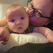 Natalie is registered to the contest to win money with this photo: baby, adult, affection, kiss, glasses, face, hand, indoor, closeup, person, child, skin, expression, cushion, comfort, love, portrait, casual, family, intimate