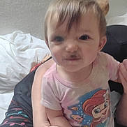 Ivy is registered to the contest to win money with this photo: toddler, child, infant, person, face, expression, smile, indoor, bed, clothing, cartoon, mermaid, hand, adult, holding, cute, funny_face, hair, skin, casual