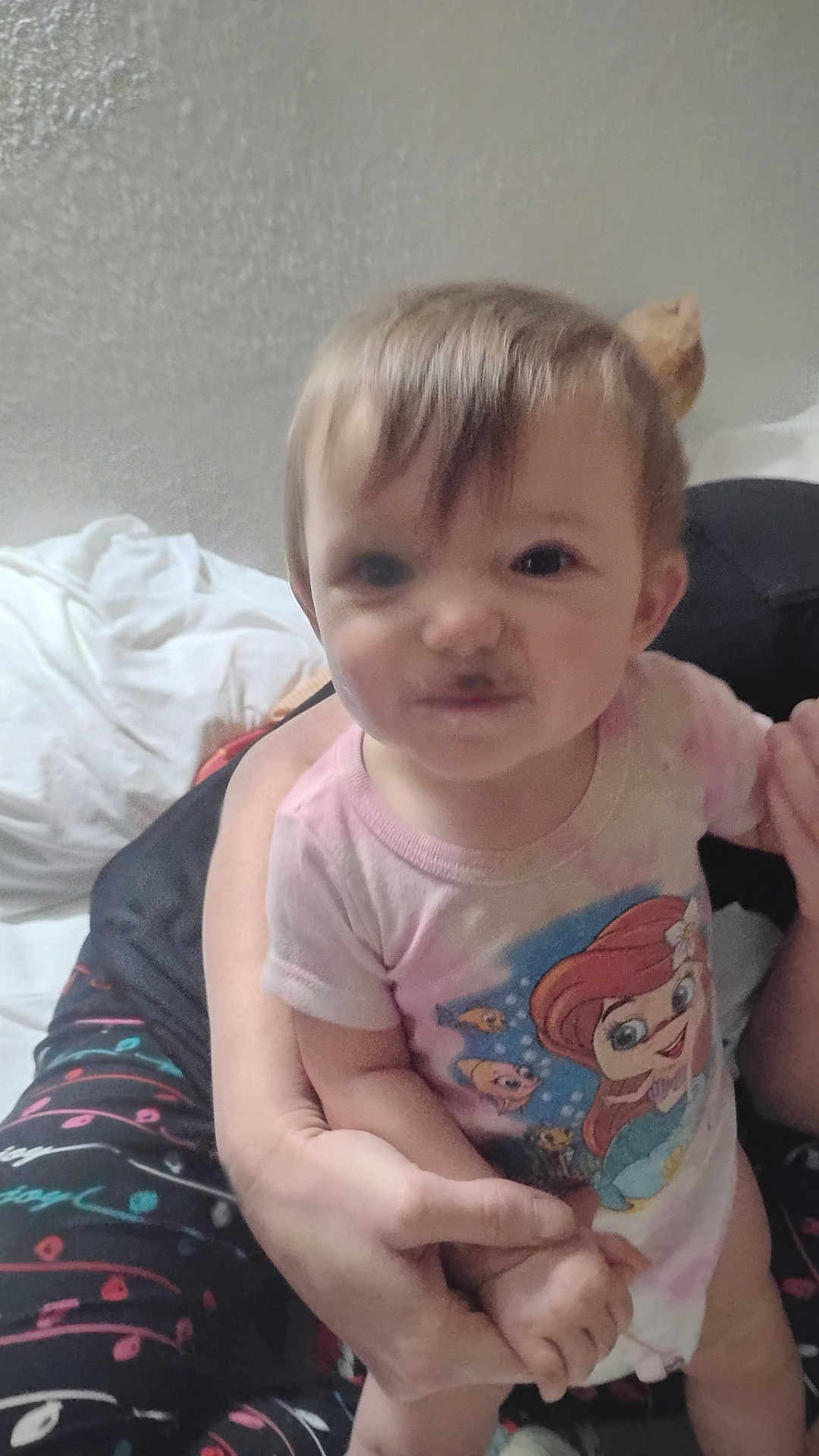 Ivy is registered to the contest to win money with this photo: toddler, child, infant, person, face, expression, smile, indoor, bed, clothing, cartoon, mermaid, hand, adult, holding, cute, funny_face, hair, skin, casual