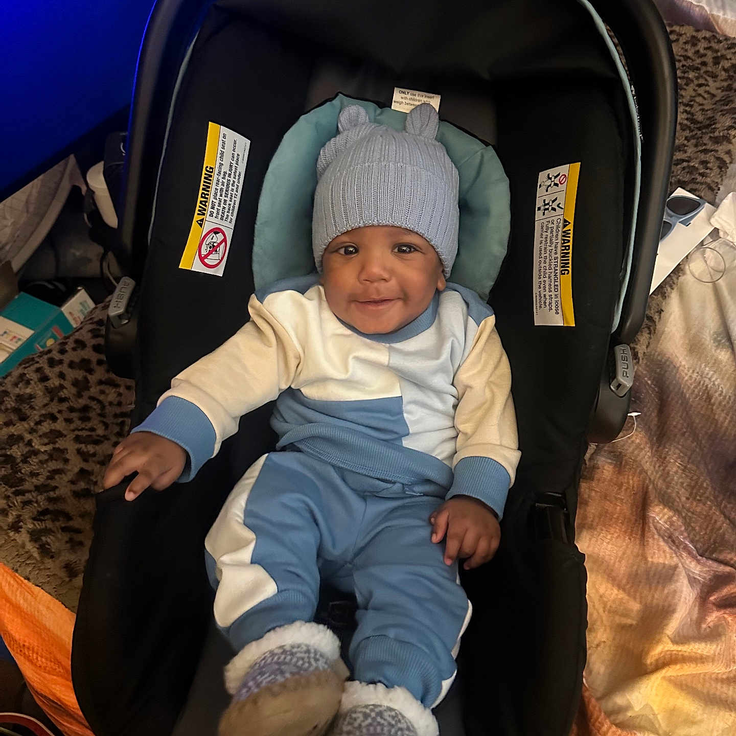 Jessiah joined the competition — help win amazing prizes! baby, car_seat, blue_hat, smile, infant, cozy_clothing, knit_hat, footwear, indoor, blanket, child, person, cute, happy, seated, warm_clothes, soft_toys, carrying_seat, headwear, toddler