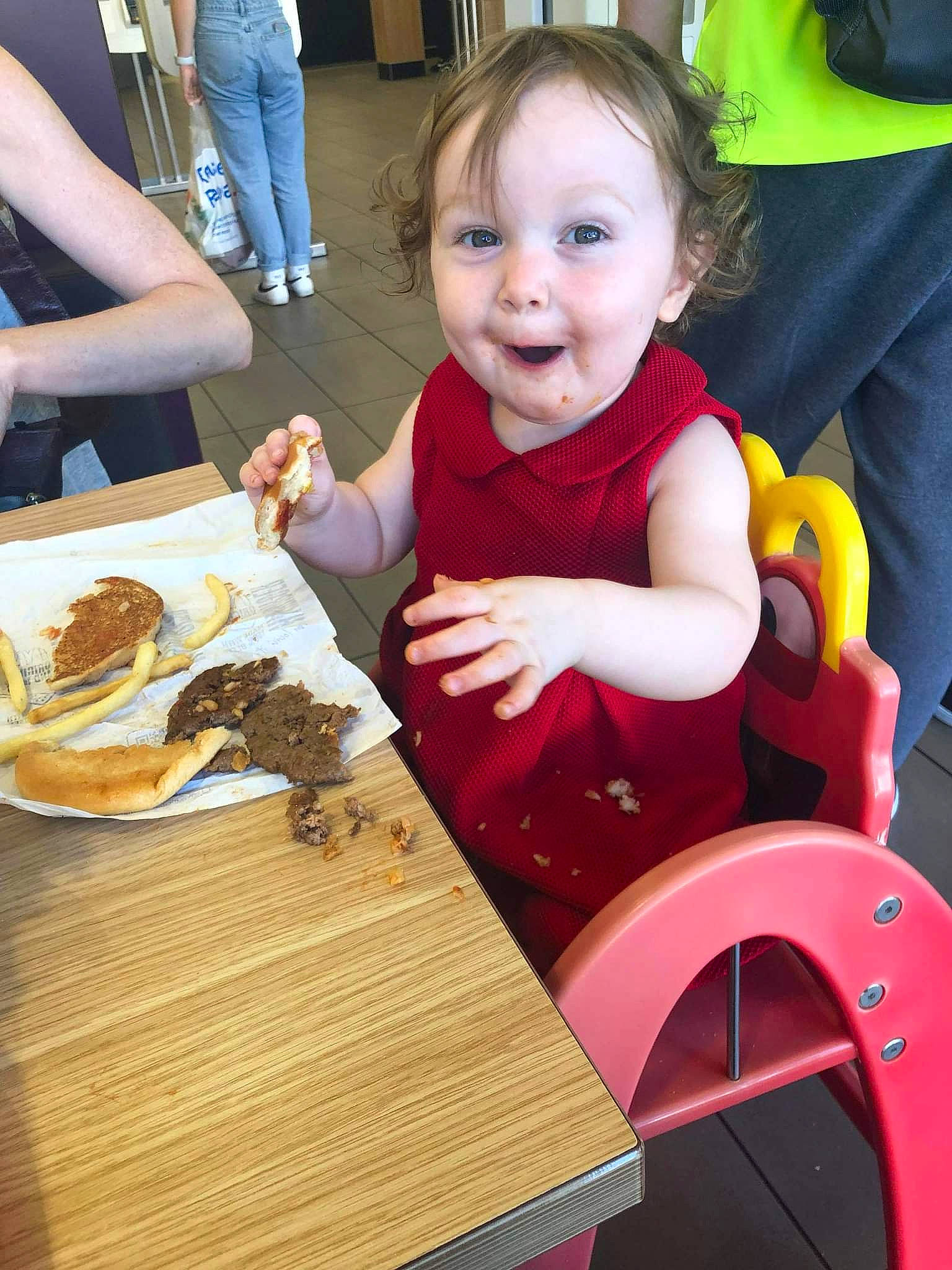 Elise May is registered to the contest to win money with this photo: arm, baby, chair, child, comfort_food, cuisine, dish, event, eye, fast_food, finger_food, food, happy, ingredient, leisure, person, plate, smile, table, tableware