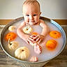 autumn_theme, baby, bath, cute, face, feet, hands, infant, metal_tub, milk_bath, milky_water, neutral_wall, orange_pumpkin, portrait, props, pumpkin, sitting, smiling, white_pumpkin, wooden_floor