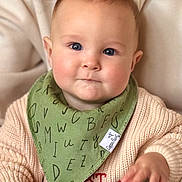 Asher joined the competition — help win amazing prizes! baby, infant, child, bib, bandana_bib, sweater, christmas_sweater, blue_eyes, chubby_cheeks, hand, close_up, portrait, indoor, caregiver, knitwear, soft_lighting, drool, neutral_expression, cozy, blurred_background