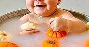 Asher is registered to the contest to win money with this photo: baby, chubby_cheeks, cute, feet, floating_objects, gourd, hands, happy, holiday_theme, infant, milkbath, orange, playful, portrait, pumpkin, skin, smile, tub, water, white