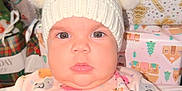 Sarahis joined the competition — help win amazing prizes! baby, child, hat, pom_poms, onesie, animal_print, chubby_cheeks, face, present, gift_wrap, holiday, festive, indoor, cute, portrait, infant, clothing, pink, white, soft