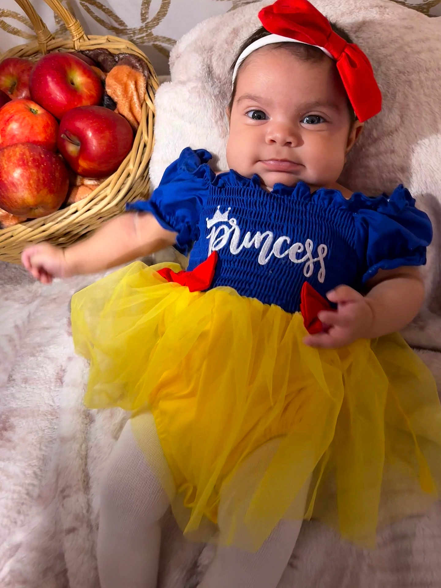 Sarahis is registered to the contest to win money with this photo: baby, child, infant, princess, dress, headband, bow, apples, basket, blanket, tights, cute, smile, portrait, indoors, colorful, soft, fabric, lying_down, person