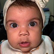 Sarahis is registered to the contest to win money with this photo: baby, child, face, headband, bow, bib, food_illustration, cupcake, donut, pie, coffee, expression, portrait, closeup, cute, infant, brown_eyes, skin, clothing, indoor
