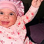 baby, child, pink_bonnet, pink_onesie, elephant_pattern, hearts, smiling, happy, waving_hand, cute, infant, face, headwear, clothing, portrait, indoors, closeup, cheerful, small_teeth, joy