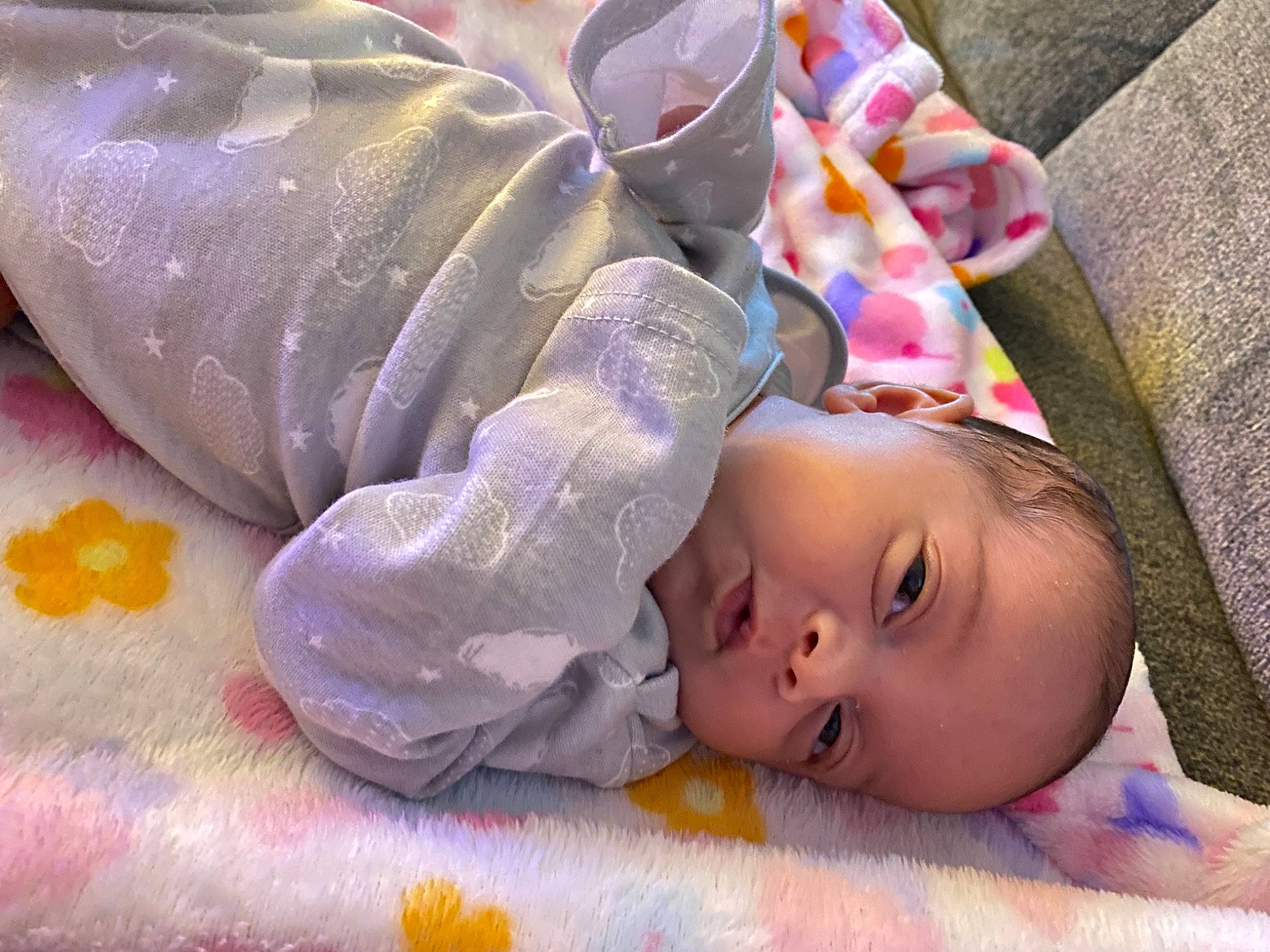 Unity is registered to the contest to win money with this photo: baby, baby_products, baby_safety, baby_toddler_clothing, bedtime, cheek, child, comfort, head, linens, nose, pattern, person, pink, purple, room, skin, textile, toddler, violet