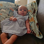 Raelynn joined the competition — help win amazing prizes! baby, child, dress, couch, pillow, pattern, horse, indoor, window, curtains, person, skin, head, legs, arm, furniture, comfort, resting, casual, portrait