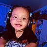 black_shirt, blanket, blue_beads, braids, child, cute, face, furniture, hair_accessory, happy, indoor, leopard_print, person, portrait, room, shelf, skin, smiling, toddler, toy