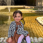 Rita a rejoint le concours — aidez-le/la à gagner de superbes lots ! casual, child, dress, fashion, fountain, girl, greenery, happy, jacket, outdoor, plants, pond, shoes, sitting, smiling, stone, sunlight, tights, water, young