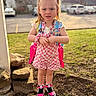 Jaime joined the competition — help win amazing prizes! child, girl, pigtails, backpack, pink, checkered, overalls, outdoor, grass, rocks, shoes, sneakers, curious, sunlight, daytime, parking_lot, trees, casual_clothing, person, young