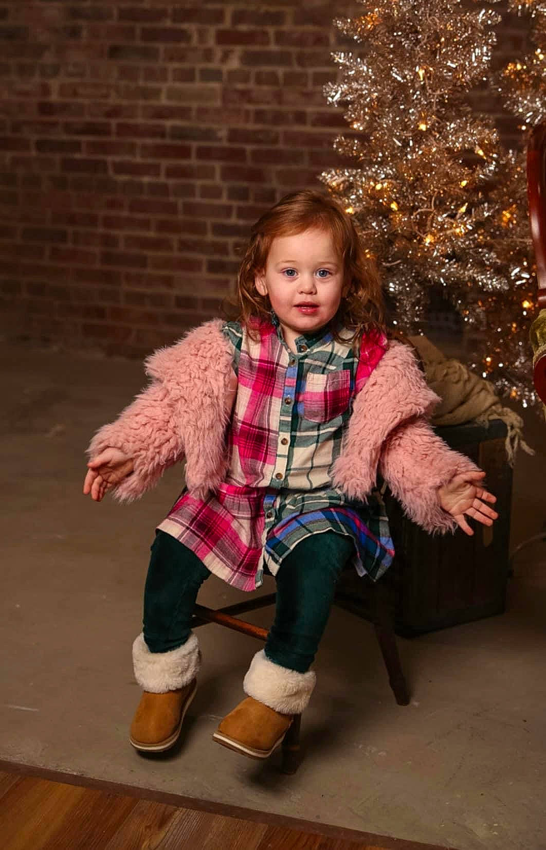 Aubree is registered to the contest to win money with this photo: child, christmas_tree, face, fashion_design, fawn, hair, hand, happy, knee, leg, long_hair, outerwear, pattern, person, pink, plaid, sleeve, sock, tartan, tree