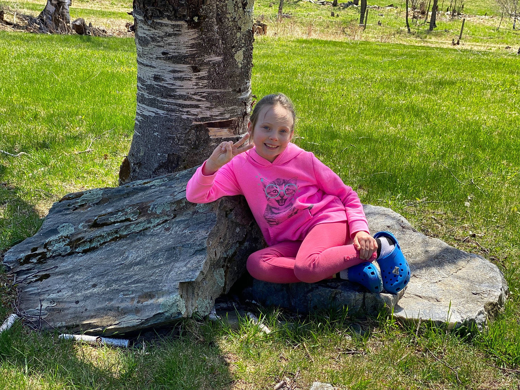 Aria is registered to the contest to win money with this photo: child, fun, grass, groundcover, jeans, joy, lap, lawn, leaf, leg, leisure, people_in_nature, person, plant, recreation, sitting, smile, t_shirt, tree, trunk