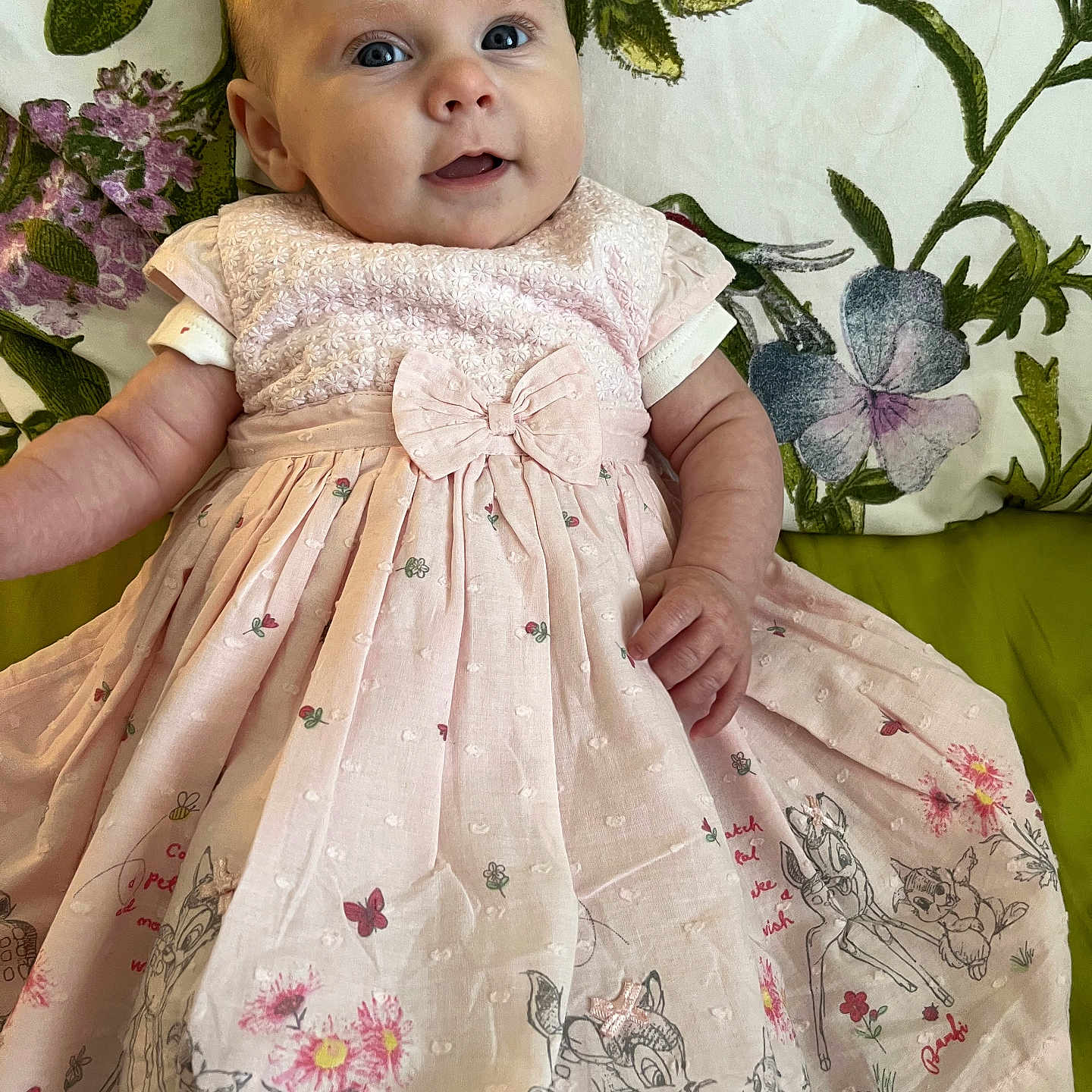 Opal joined the competition — help win amazing prizes! baby, bow, cartoon_print, child, clothing, cute, dress, fabric, face, floral_background, flower, happy, indoors, infant, person, pink, portrait, sitting, smiling, young_child