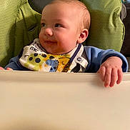 Cooper joined the competition — help win amazing prizes! baby, high_chair, bib, food, smile, child, infant, hand, face, clothing, seat, green, blue, cute, young, indoor, feeding, expression, person, toddler