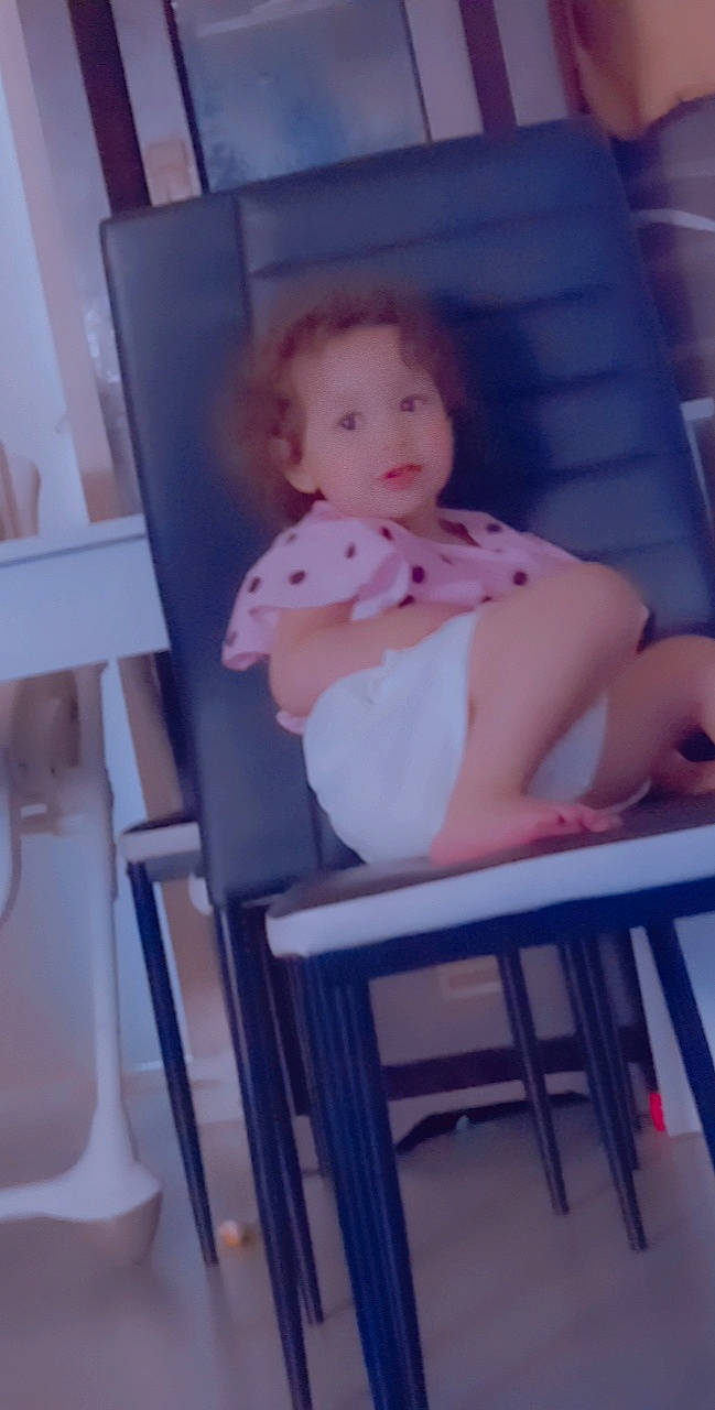 Sara a rejoint le concours — aidez-le/la à gagner de superbes lots ! baby, baby_products, baby_safety, baby_toddler_clothing, barefoot, chair, chest, child, eye, flooring, foot, human_leg, knee, person, room, shorts, sitting, table, thigh, toddler