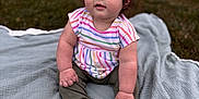 Myla joined the competition — help win amazing prizes! baby, child, outdoor, grass, blanket, pink_bow, curly_hair, blue_eyes, striped_shirt, sitting, cute, portrait, infant, soft_light, greenery, casual_clothing, natural_light, face, small_feet, attention