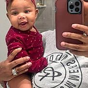 Zaya joined the competition — help win amazing prizes! baby, child, person, adult, mirror, selfie, phone, headband, bow, polka_dot, maroon, clothing, hand, ring, smile, dimples, face, bathroom, tiles, casual