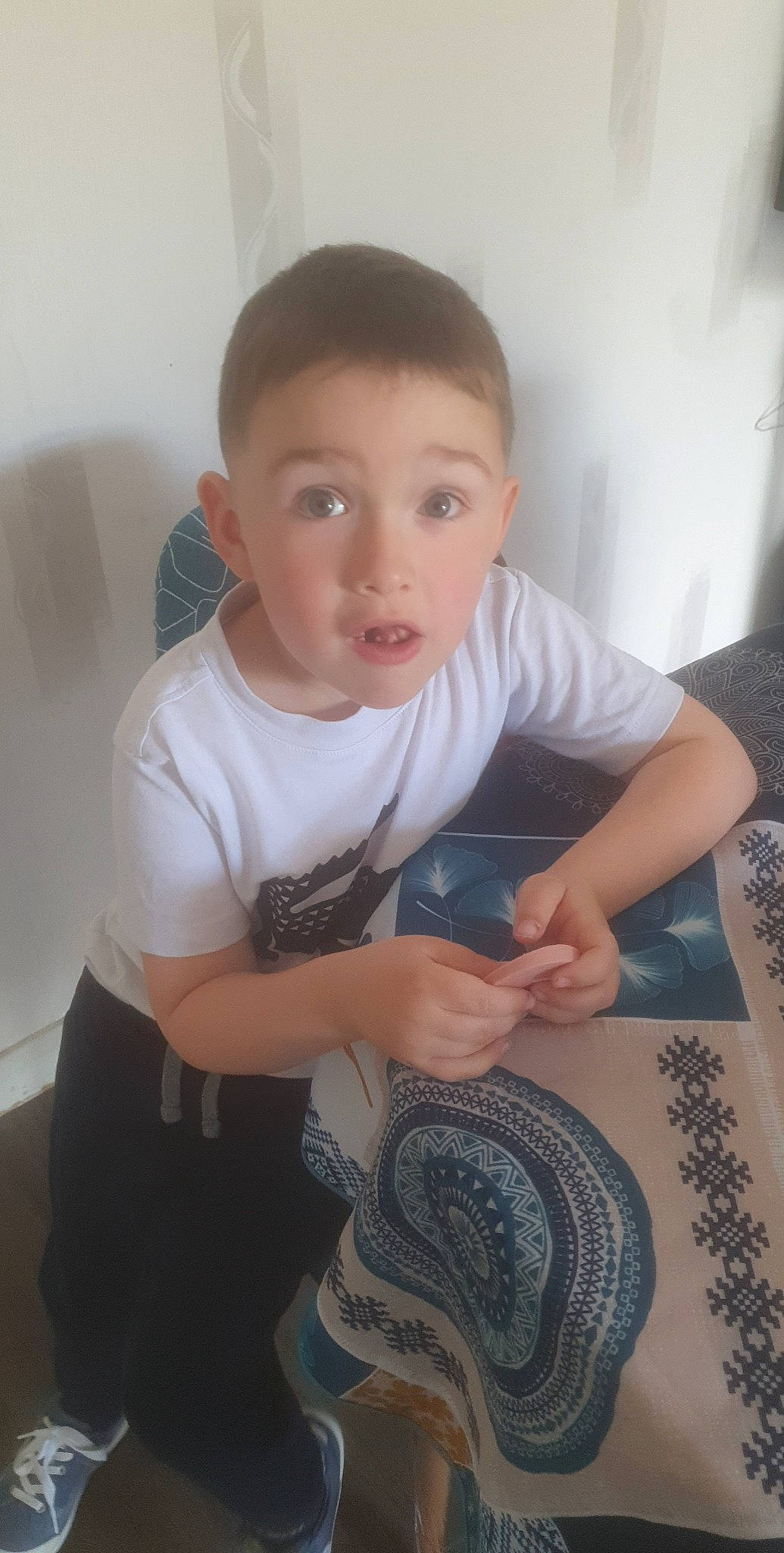 Nolan participe au concours pour gagner de l'argent avec cette photo : arm, art, automotive_wheel_system, cheek, child, elbow, flooring, happy, neck, organ, pattern, person, pottery, room, sitting, skin, sleeve, surprise, t_shirt, thumb